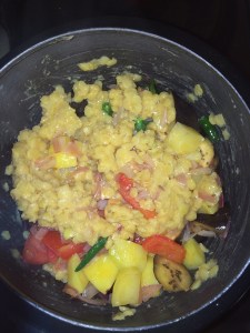 Transfer the sautéed vegetables into a pressure cooker and add half the cooked toor dal.