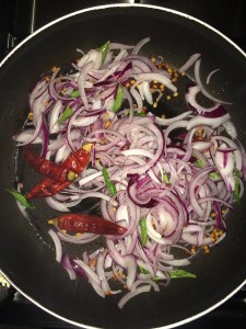 Add dry red chilies and chopped onion and saute for a while.