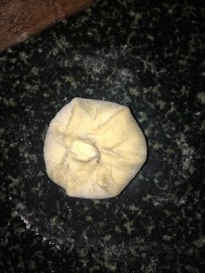 Cover the stuffing with the dough on all sides and make a round parcel. Remove the excess dough if any.