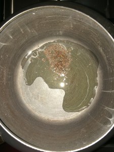 Take oil in a pressure cooker and splutter mustard.