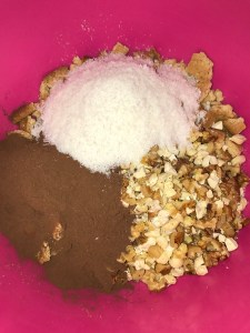 Now add the nuts, desiccated coconut and cocoa powder to the biscuits.