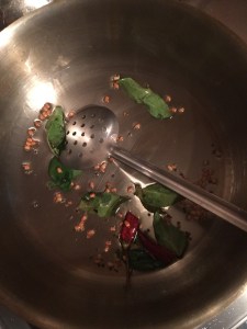 Then add the broken dry red chilies and curry leaves.